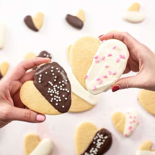 Overhead shot of Valentine's Day Cookies being held by two hands.