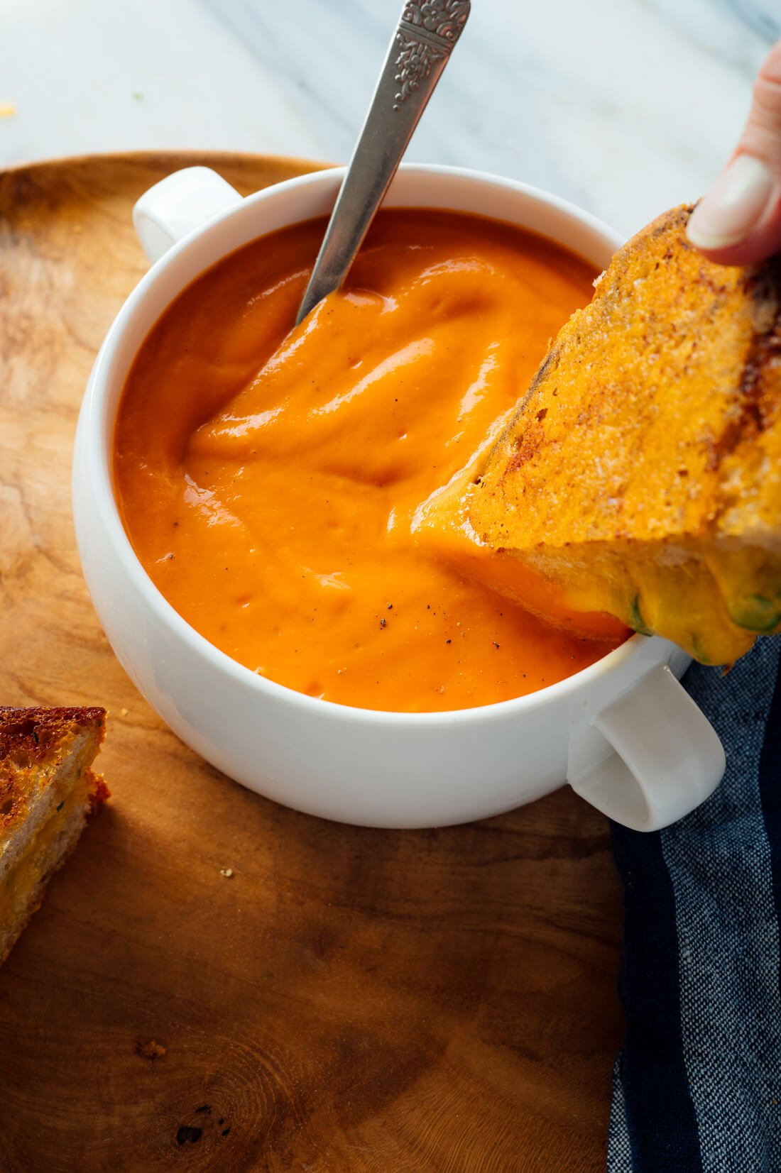 grilled cheese dipping into tomato soup