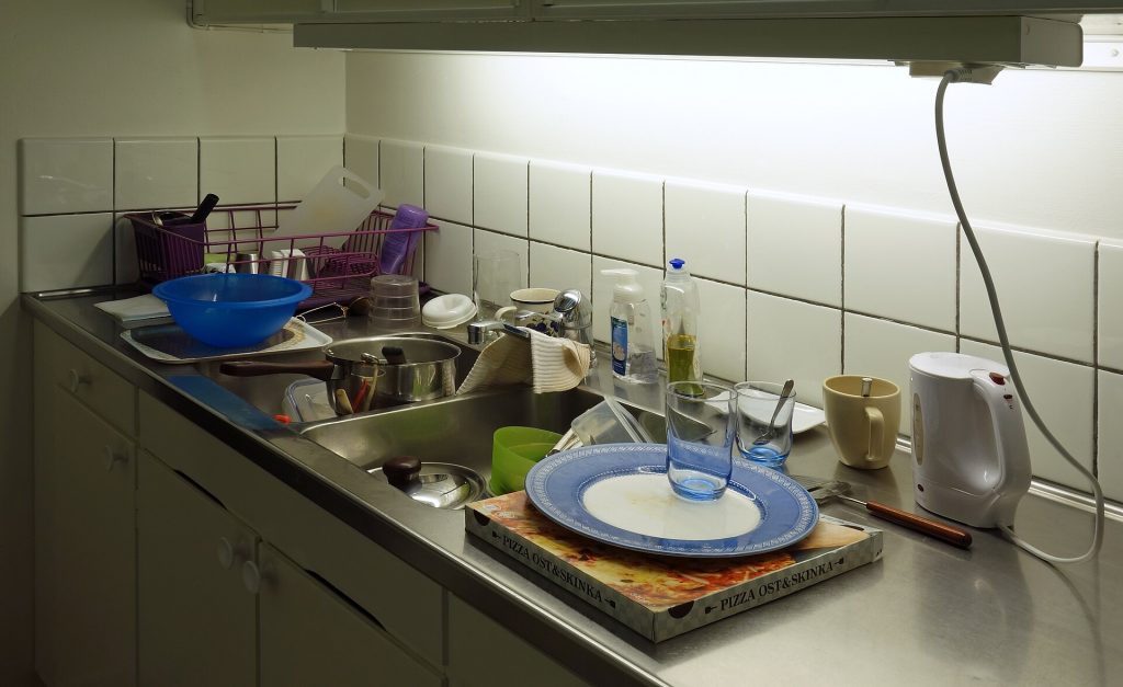 A hand washing sink with soap dispenser in a restaurant kitchen