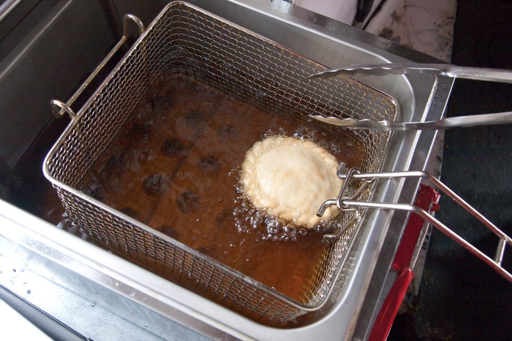 Stainless steel commercial deep fryer baskets on a kitchen line