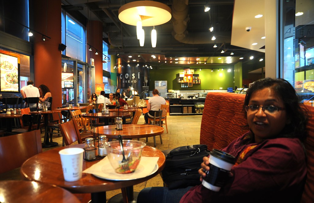 Co-worker Monalisa holding a paper cup of coffee, salad bowl, tables, lights, cafe, COSI Bread Restaurant, Chi