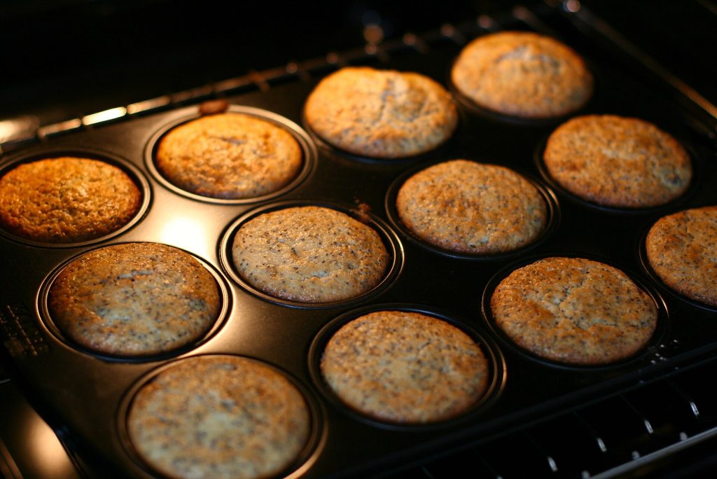 Sheet pans of food baking on racks inside a convection oven
