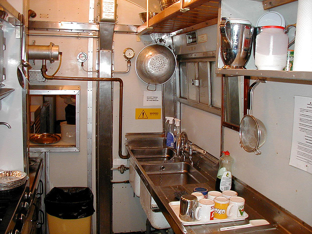 A busy commercial kitchen line with cooks at each station