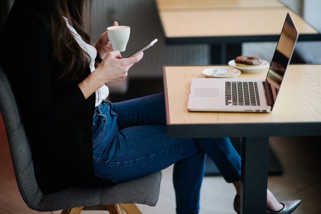 A laptop open on a cafe table, ready to reply to reviews