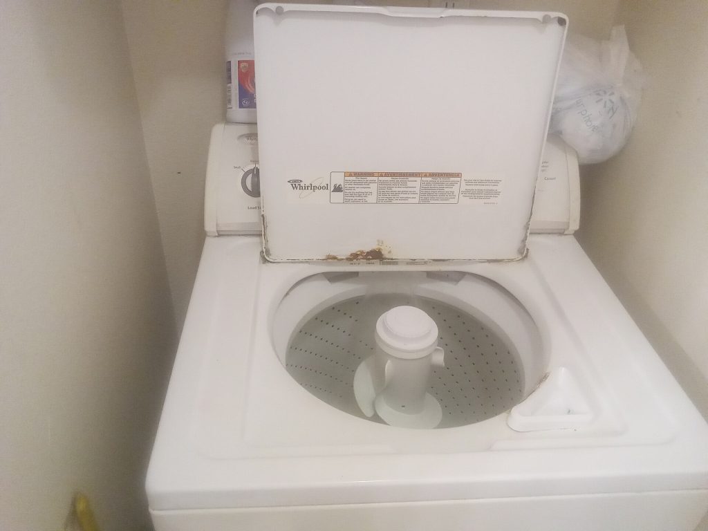A commercial front-loading washing machine in a laundry room