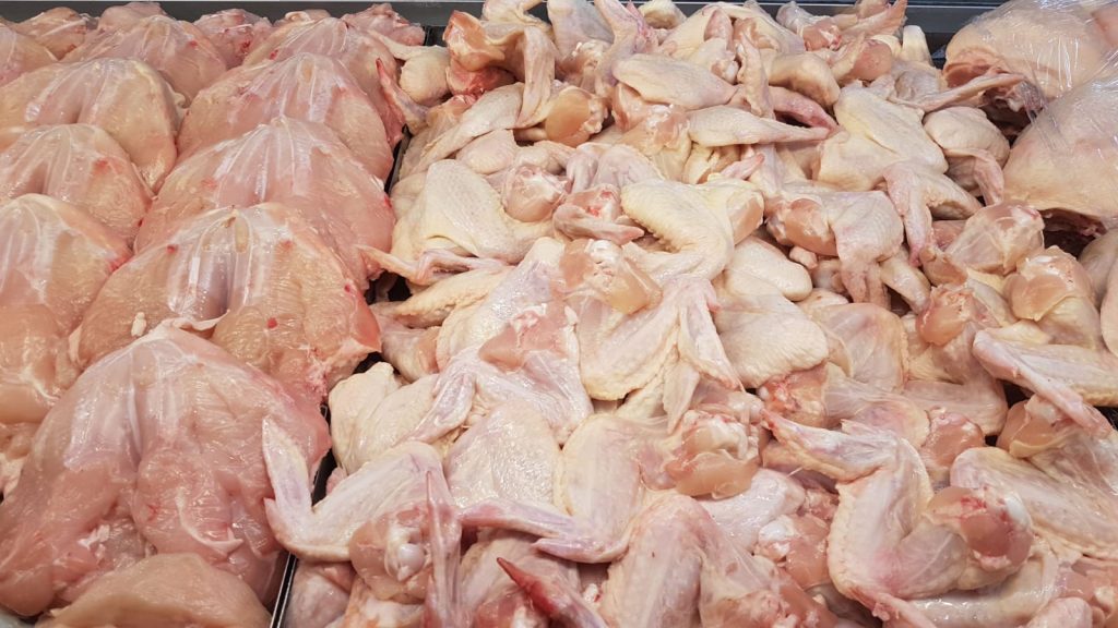 Frozen raw chicken breasts on a tray before thawing