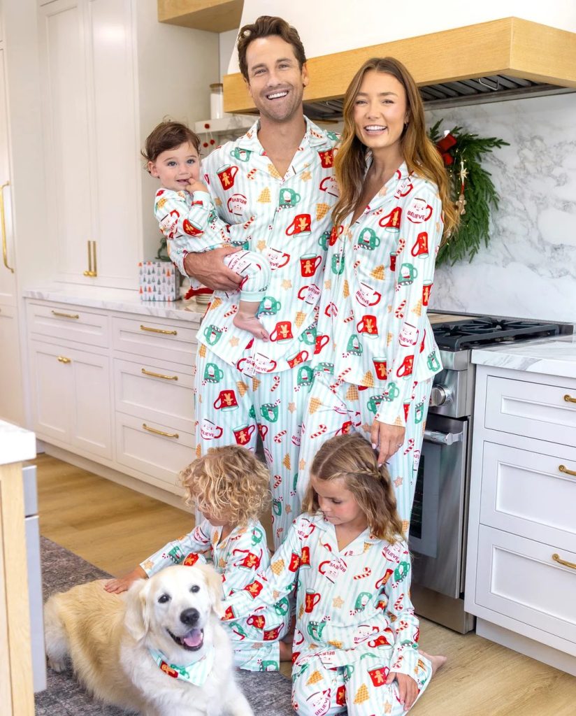 Family in matching Christmas mug-print teal pajamas in a kitchen on Christmas morning